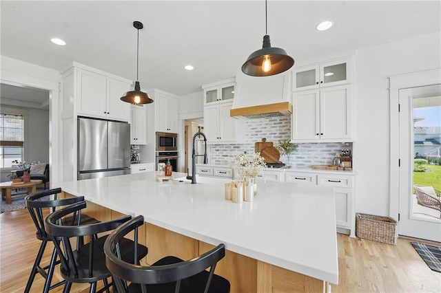 16555 S Lichtenauer Dr, Olathe, KS 66062 - kitchen with appliances with stainless steel finishes, light wood finished floors, tasteful backsplash, white cabinetry, and recessed lighting