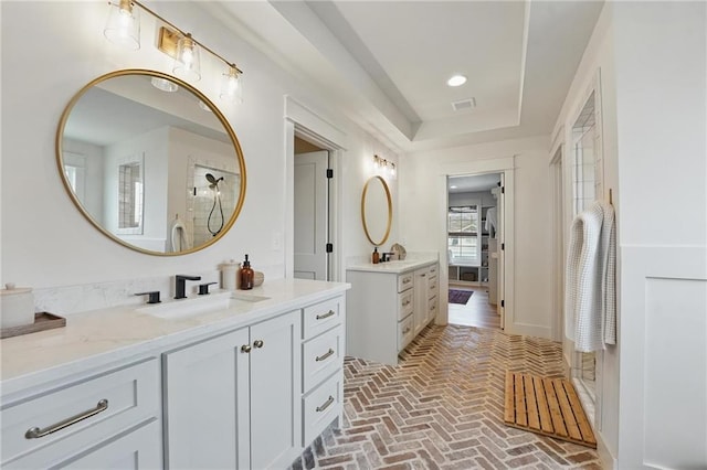 16555 S Lichtenauer Dr, Olathe, KS 66062 - bathroom featuring brick flooring, two vanities, and a raised ceiling
