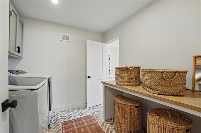 16555 S Lichtenauer Dr, Olathe, KS 66062 - laundry room with brick patterned flooring, separate washer and dryer, and cabinet space