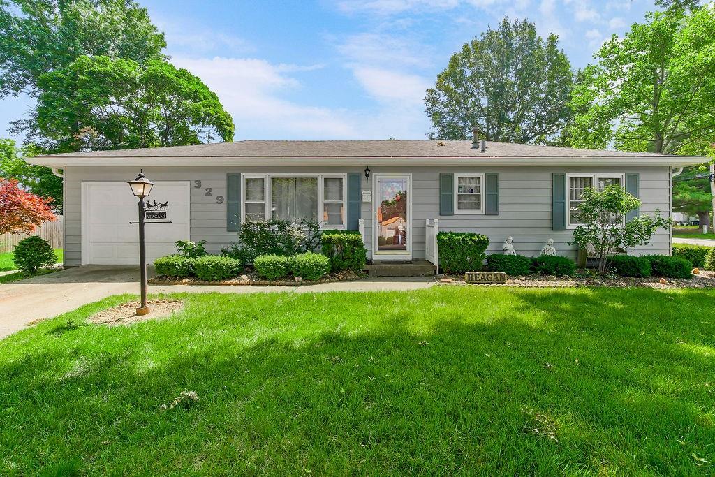 329 Hazel St, Buckner, MO 64016 - ranch-style house featuring a front yard, an attached garage, and concrete driveway