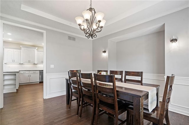 17940 W 158th Ct, Olathe, KS 66062 - dining room featuring a chandelier, dark wood-type flooring, a wainscoted wall, a tray ceiling, and a decorative wall