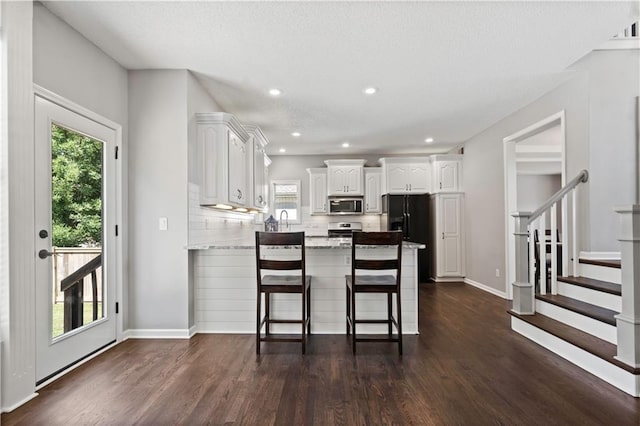17940 W 158th Ct, Olathe, KS 66062 - kitchen with stainless steel appliances, a peninsula, plenty of natural light, white cabinetry, and recessed lighting