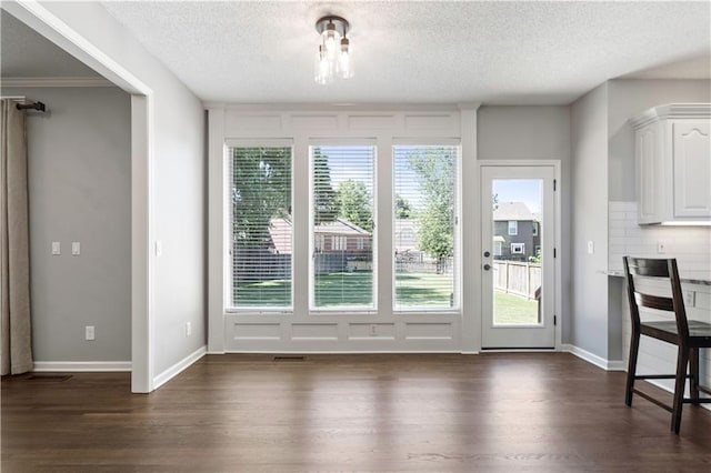 17940 W 158th Ct, Olathe, KS 66062 - unfurnished dining area featuring dark wood-type flooring, healthy amount of natural light, and a textured ceiling