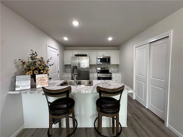 822 Carolina St, Neodesha, KS 66757 - kitchen featuring appliances with stainless steel finishes, a peninsula, white cabinets, dark wood-type flooring, and recessed lighting