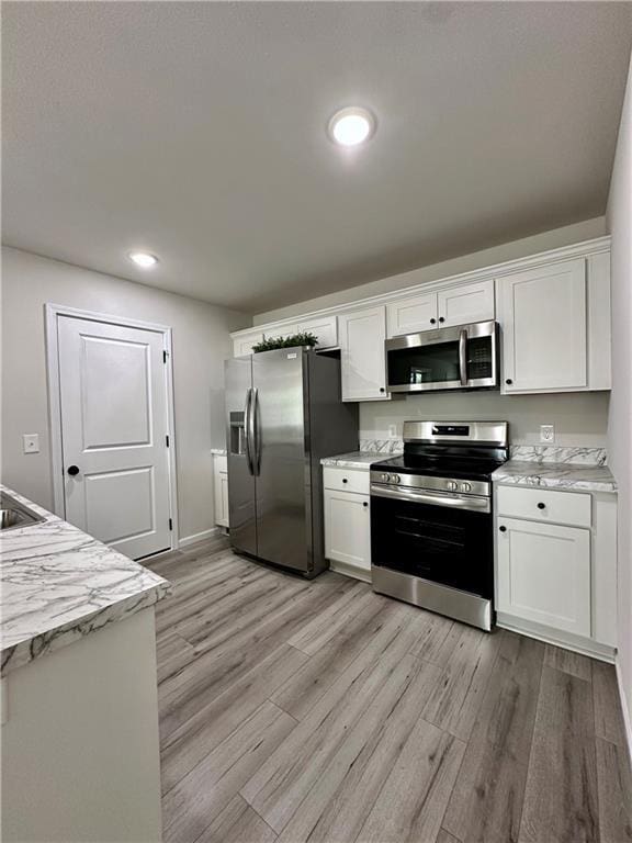 822 Carolina St, Neodesha, KS 66757 - kitchen with stainless steel appliances, white cabinetry, light wood finished floors, and recessed lighting