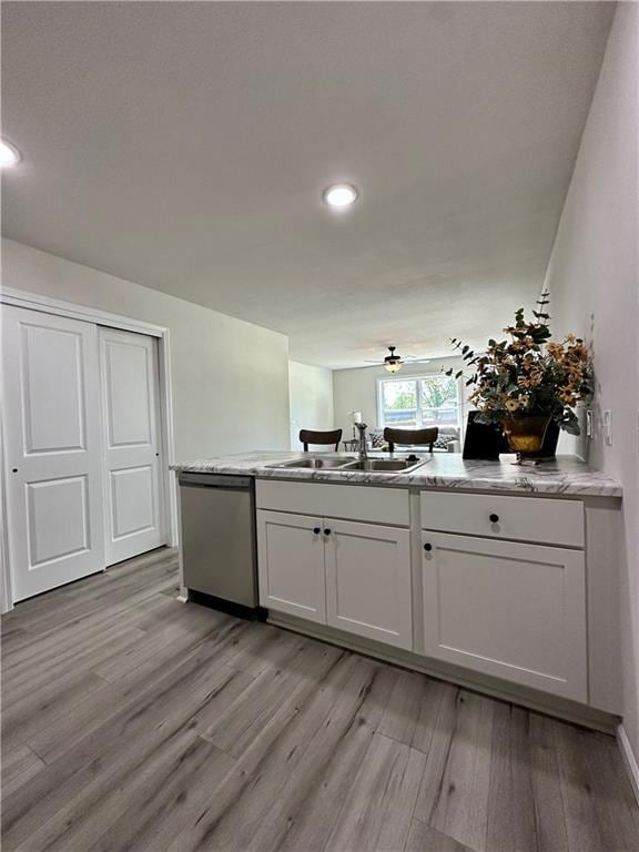822 Carolina St, Neodesha, KS 66757 - kitchen with stainless steel dishwasher, light wood-style flooring, recessed lighting, and white cabinetry
