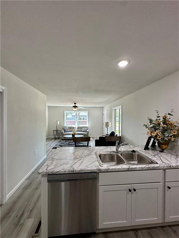 822 Carolina St, Neodesha, KS 66757 - kitchen featuring dishwasher, light wood-style flooring, a peninsula, recessed lighting, and light stone countertops