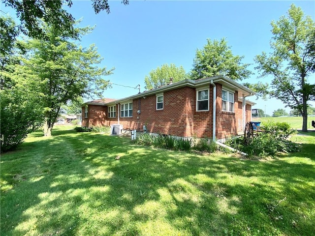 311 SW 12th Ter, Concordia, MO 64020 - rear view of property featuring brick siding, a lawn, and central AC