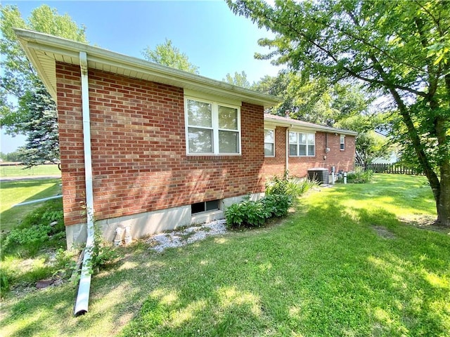 311 SW 12th Ter, Concordia, MO 64020 - view of property exterior with a lawn, brick siding, and central AC unit