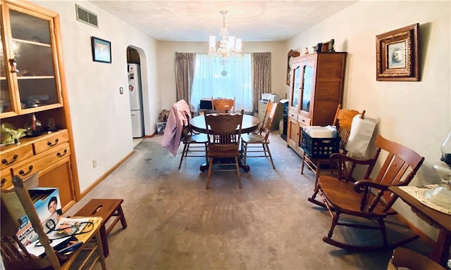 311 SW 12th Ter, Concordia, MO 64020 - carpeted dining space with arched walkways and a chandelier