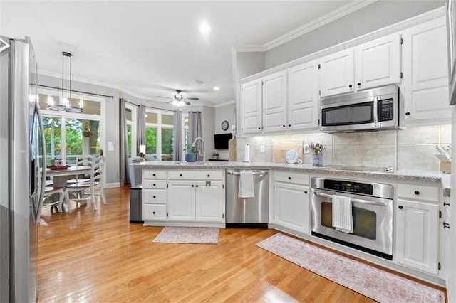 10181 S Shadow Cir, Olathe, KS 66061 - kitchen with appliances with stainless steel finishes, a peninsula, ornamental molding, light wood-style flooring, and white cabinetry