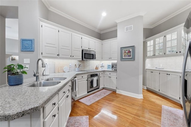 10181 S Shadow Cir, Olathe, KS 66061 - kitchen featuring stainless steel appliances, white cabinets, light wood-style floors, backsplash, and ornamental molding