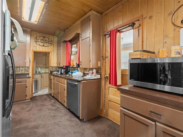 2605 S 15th St, Saint Joseph, MO 64503 - kitchen with stainless steel appliances, wooden ceiling, wooden walls, dark colored carpet, and dark countertops