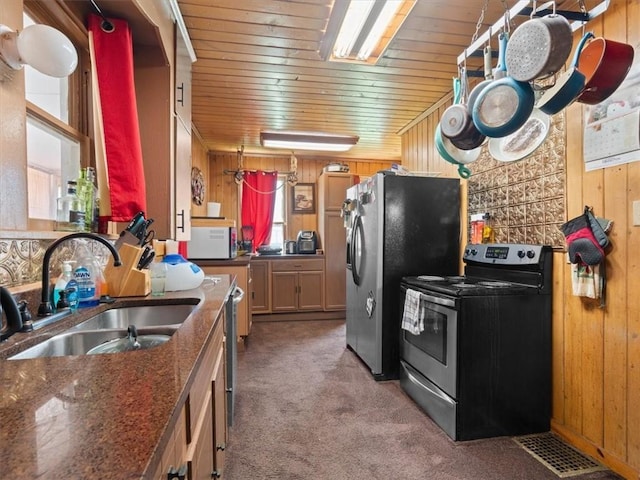 2605 S 15th St, Saint Joseph, MO 64503 - kitchen with stainless steel appliances, wooden walls, wood ceiling, and light carpet