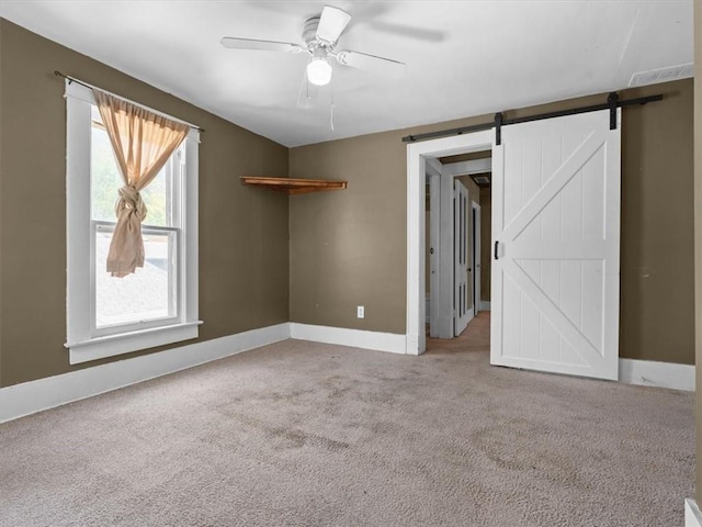 2605 S 15th St, Saint Joseph, MO 64503 - spare room featuring carpet flooring, a ceiling fan, and a barn door