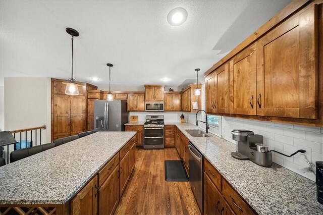 14115 NW 68th St, Parkville, MO 64152 - kitchen featuring appliances with stainless steel finishes, brown cabinetry, dark wood-type flooring, a kitchen island, and recessed lighting