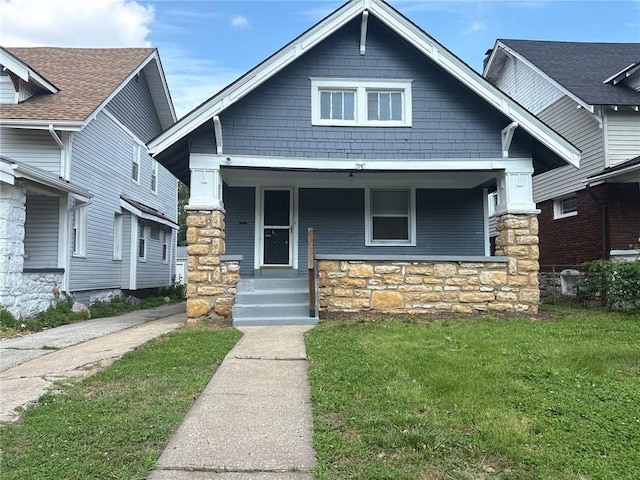 3307 Askew Ave, Kansas City, MO 64128 - craftsman-style home featuring a porch, a front yard, and stone siding