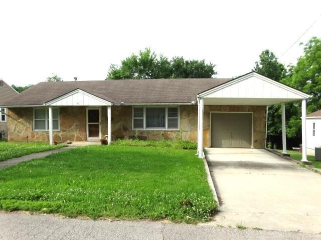 503 Hickory St, Richmond, MO 64085 - view of front of home with a garage, stone siding, a front lawn, concrete driveway, and a carport