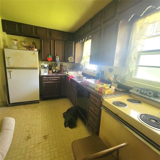 503 Hickory St, Richmond, MO 64085 - kitchen with electric range oven, freestanding refrigerator, dishwasher, and plenty of natural light