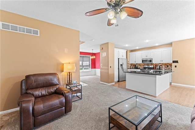 20112 W 220th St, Spring Hill, KS 66083 - living room with light colored carpet, a ceiling fan, a textured ceiling, and recessed lighting