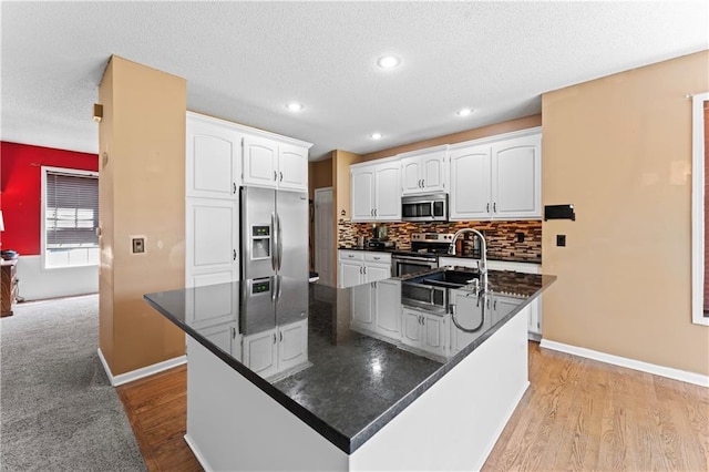 20112 W 220th St, Spring Hill, KS 66083 - kitchen with stainless steel appliances, dark countertops, white cabinetry, a large island, and decorative backsplash