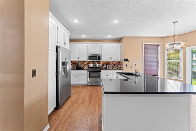 20112 W 220th St, Spring Hill, KS 66083 - kitchen featuring stainless steel appliances, dark countertops, a textured ceiling, white cabinets, and tasteful backsplash