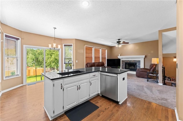 20112 W 220th St, Spring Hill, KS 66083 - kitchen with stainless steel dishwasher, a textured ceiling, a ceiling fan, wood finished floors, and dark countertops