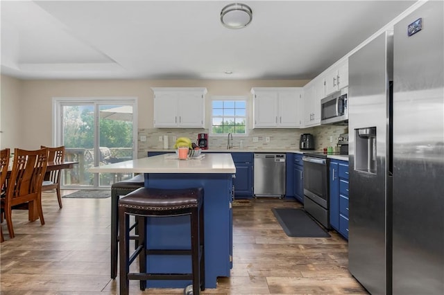 15375 Roger Rd, Leavenworth, KS 66048 - kitchen with stainless steel appliances, blue cabinets, a center island, light countertops, and white cabinets
