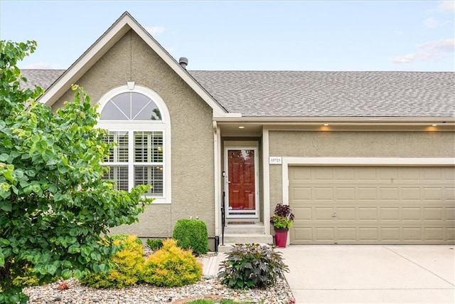 15723 W 61st Ter, Shawnee, KS 66217 - view of front of property featuring driveway, stucco siding, roof with shingles, and an attached garage