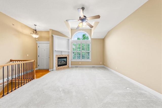 15723 W 61st Ter, Shawnee, KS 66217 - unfurnished living room featuring carpet flooring, ceiling fan, lofted ceiling, and a tile fireplace
