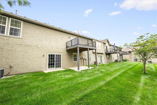 15723 W 61st Ter, Shawnee, KS 66217 - back of property featuring stucco siding, a lawn, a patio area, and a balcony