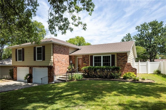 315 Goodrich Dr, Warrensburg, MO 64093 - split level home with brick siding, an attached garage, and driveway