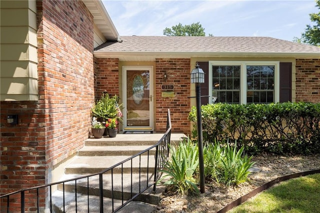 315 Goodrich Dr, Warrensburg, MO 64093 - view of exterior entry with brick siding and roof with shingles