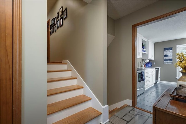 315 Goodrich Dr, Warrensburg, MO 64093 - stairway with tile patterned floors and a textured ceiling