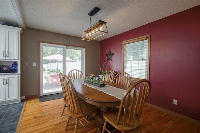 315 Goodrich Dr, Warrensburg, MO 64093 - dining space featuring light wood finished floors, a textured ceiling, and a chandelier