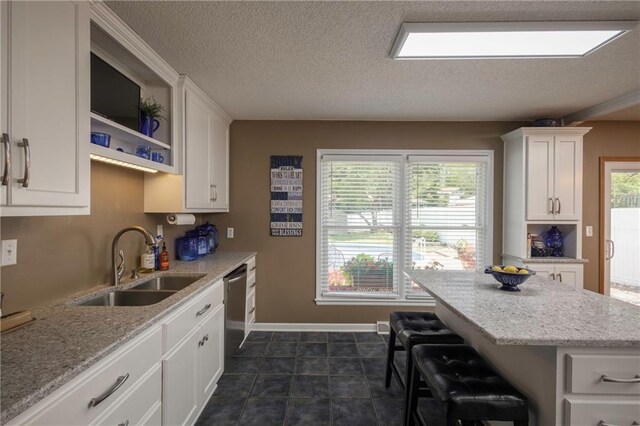 315 Goodrich Dr, Warrensburg, MO 64093 - kitchen with white cabinets, a textured ceiling, dishwasher, and light stone counters