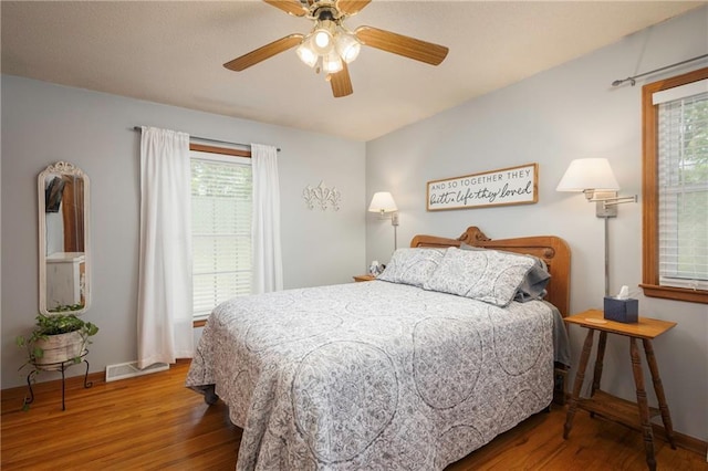 315 Goodrich Dr, Warrensburg, MO 64093 - bedroom with wood finished floors, multiple windows, and a ceiling fan