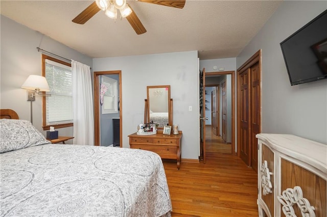 315 Goodrich Dr, Warrensburg, MO 64093 - bedroom featuring light wood-style floors, a textured ceiling, a ceiling fan, and a closet