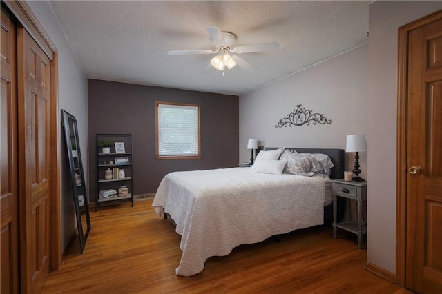 315 Goodrich Dr, Warrensburg, MO 64093 - bedroom featuring light wood-type flooring, a textured ceiling, a ceiling fan, and a closet