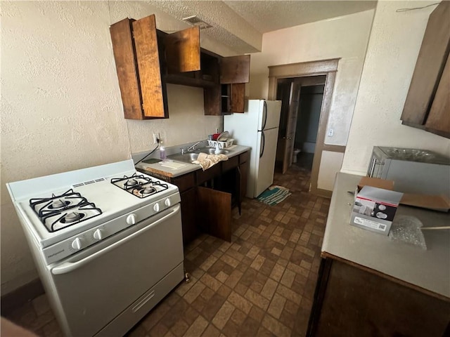 2416 E 22nd St, Kansas City, MO 64127 - kitchen with white appliances, brick patterned floors, light countertops, and a textured wall