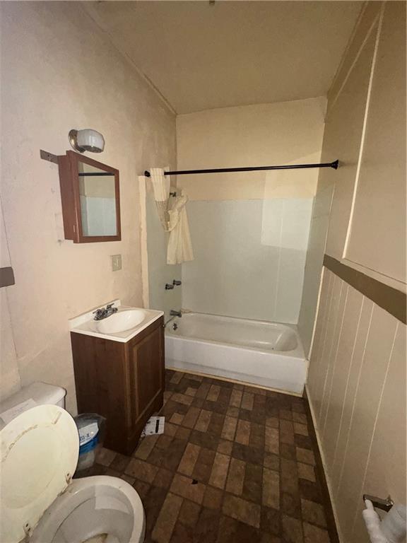 2416 E 22nd St, Kansas City, MO 64127 - bathroom with shower / tub combo with curtain and vanity