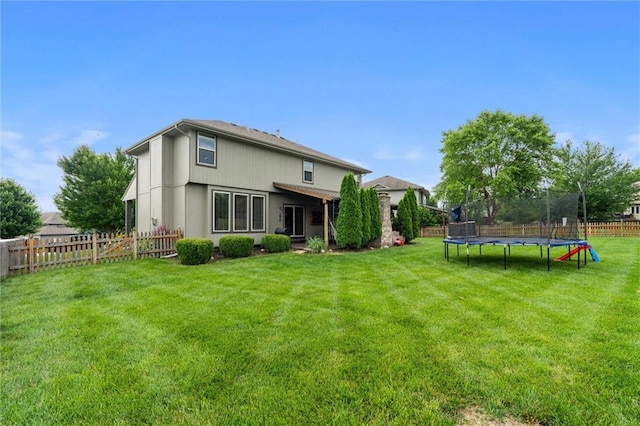 514 NE Viewpark Dr, Lees Summit, MO 64086 - rear view of property with a trampoline and a fenced backyard