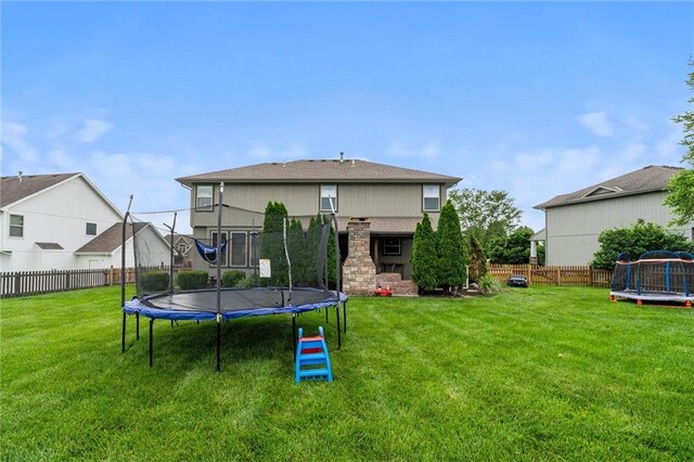 514 NE Viewpark Dr, Lees Summit, MO 64086 - rear view of property featuring a trampoline and a fenced backyard
