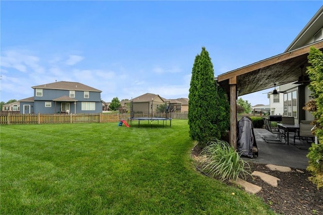 514 NE Viewpark Dr, Lees Summit, MO 64086 - fenced backyard featuring a trampoline, ceiling fan, a patio, outdoor dining area, and a residential view
