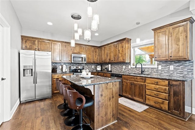 514 NE Viewpark Dr, Lees Summit, MO 64086 - kitchen featuring stainless steel appliances, a kitchen island, dark stone countertops, dark wood-style flooring, and recessed lighting