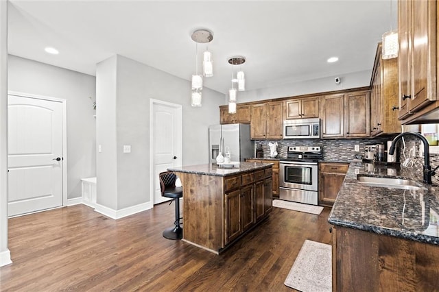 514 NE Viewpark Dr, Lees Summit, MO 64086 - kitchen with stainless steel appliances, dark wood-type flooring, backsplash, a kitchen island, and dark stone countertops