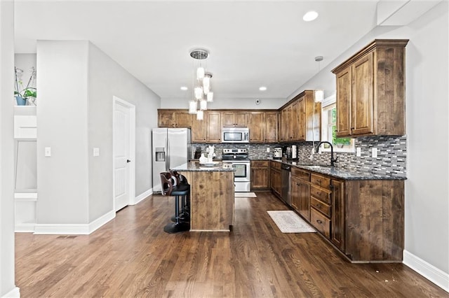 514 NE Viewpark Dr, Lees Summit, MO 64086 - kitchen with stainless steel appliances, dark wood finished floors, decorative backsplash, dark stone countertops, and recessed lighting