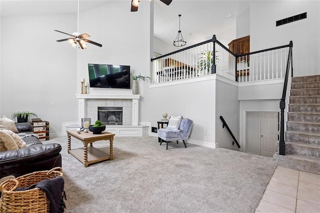 29500 W 184th St, Gardner, KS 66030 - tiled living room with a ceiling fan, a high ceiling, a tiled fireplace, and carpet