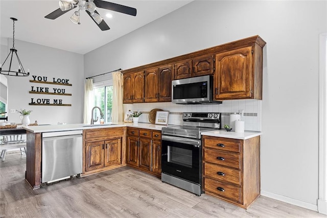 29500 W 184th St, Gardner, KS 66030 - kitchen with appliances with stainless steel finishes, light countertops, ceiling fan, light wood-style floors, and backsplash