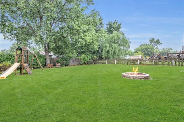 22005 Gracie Dr, Peculiar, MO 64078 - fenced backyard featuring an outdoor fire pit and a playground